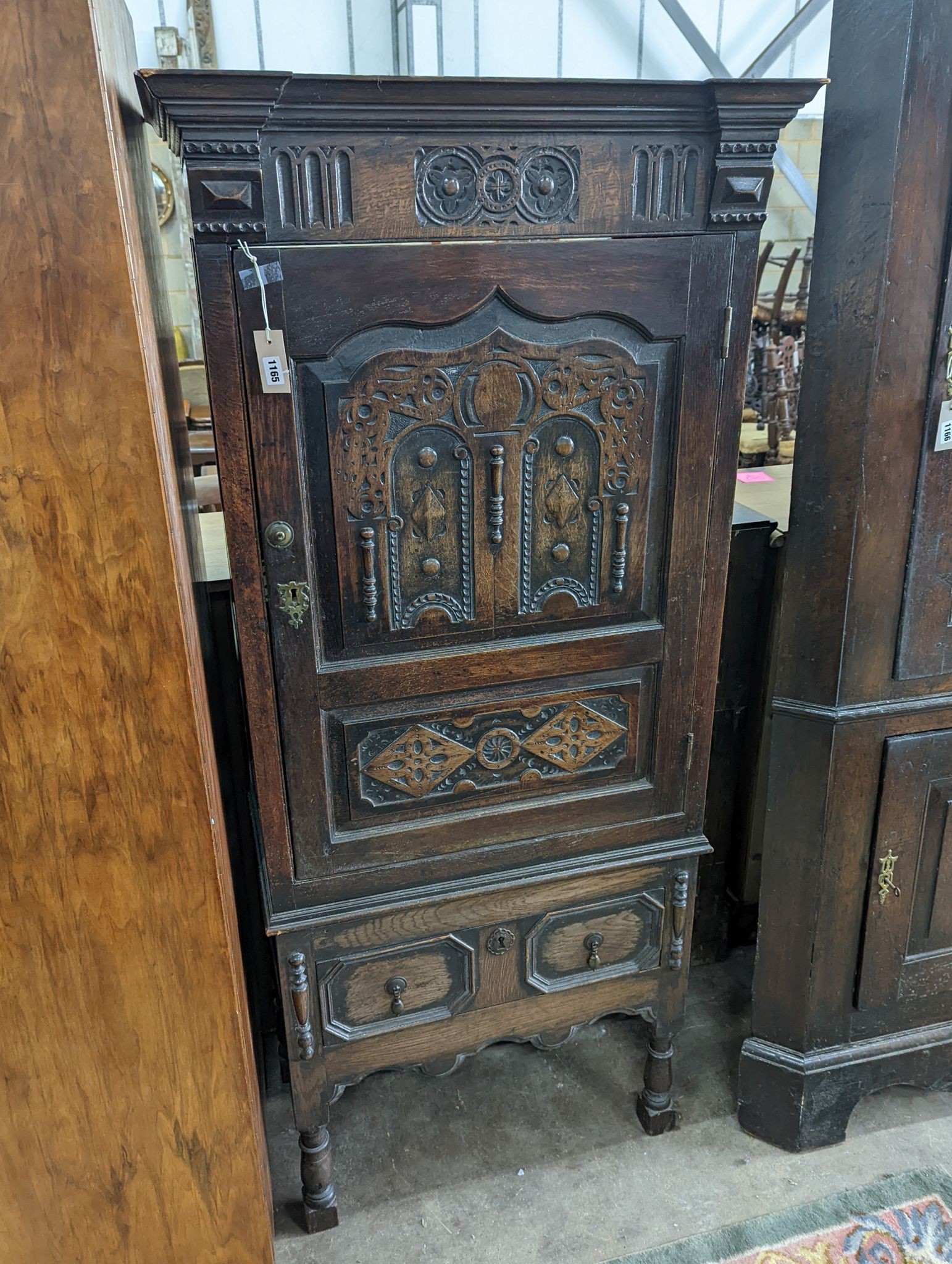 A 17th century style carved panelled oak side cabinet, width 76cm, depth 43cm, height 173cm